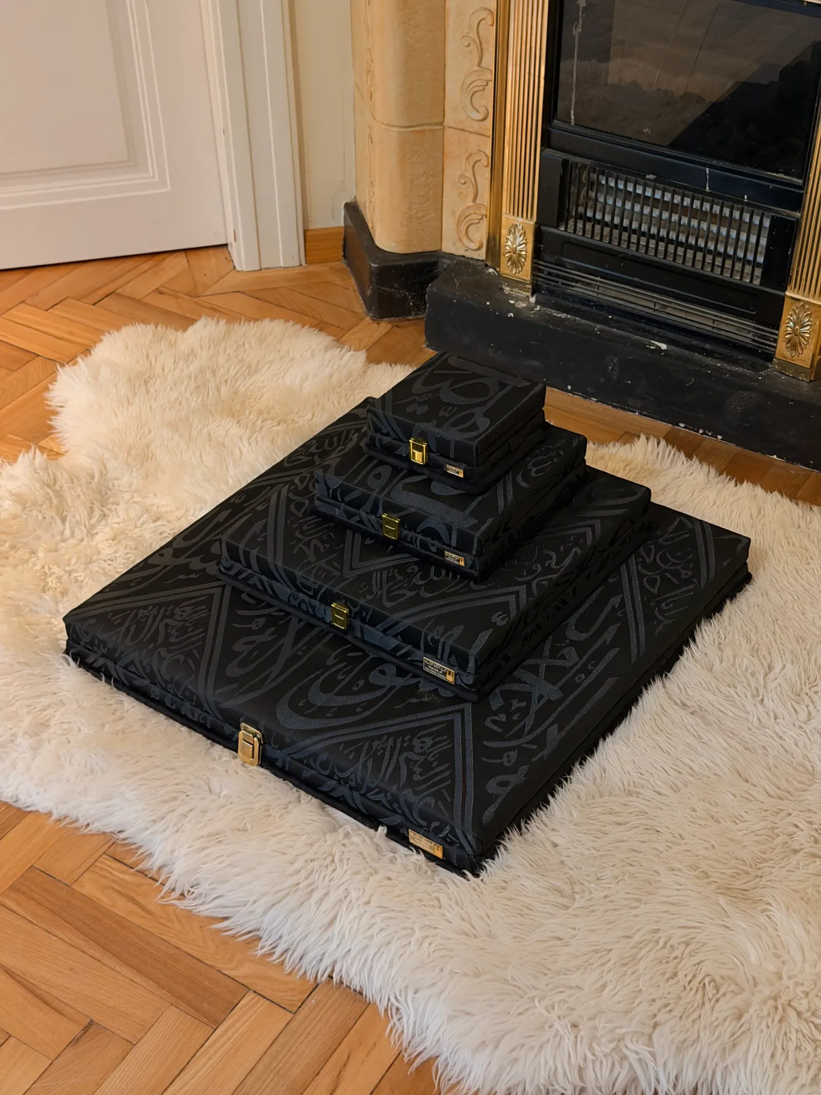 Vier schwarze Kiswah-Präsentationsboxen als Pyramide gestapelt