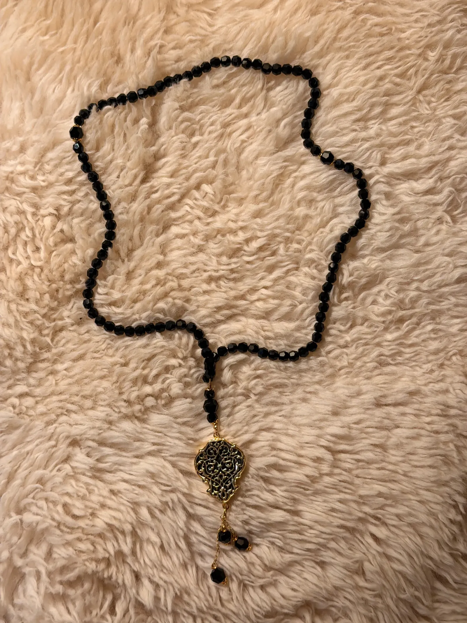 Kette aus schwarzen Kristallperlen mit goldfarbenem Filigran-Medaillon und Perlengehängen