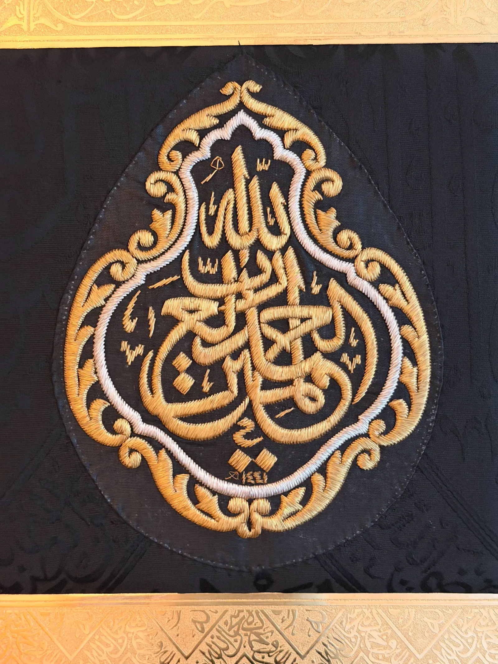 Makroaufnahme der Kiswah-Stickerei aus Gold- und Silberfäden auf schwarzer Seide